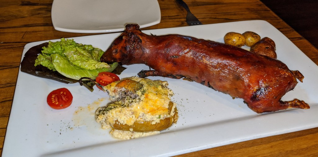 a roasted guinea pig sits on a dish